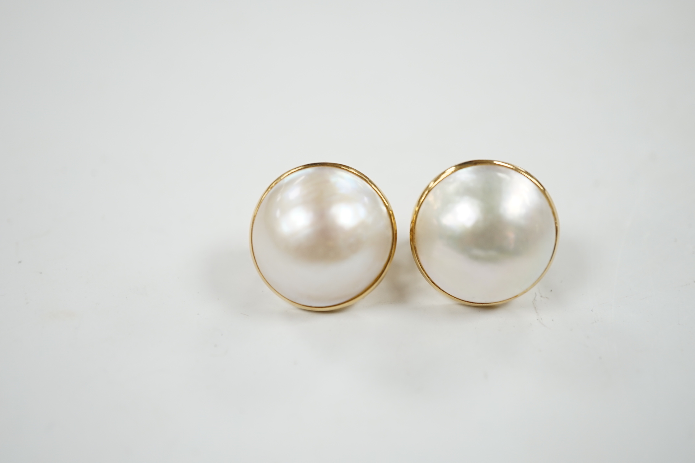 A modern pair of 750 yellow metal and mabe pearl set earrings, diameter 18mm, gross weight 11.9 grams.